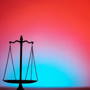 Silhouette of legal scales against a somber backdrop.